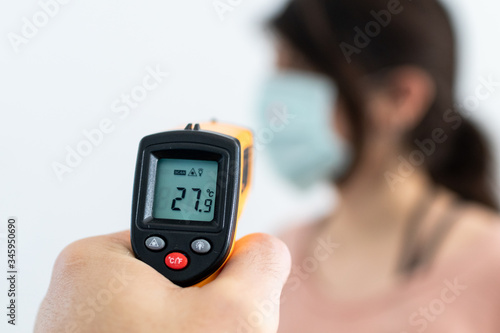 Check temperature for disease with contactless thermometer. Temperature control preventing spread of virus pandemic. Covid-19, Coronavirus measure to control diffusion. White background blurred figure