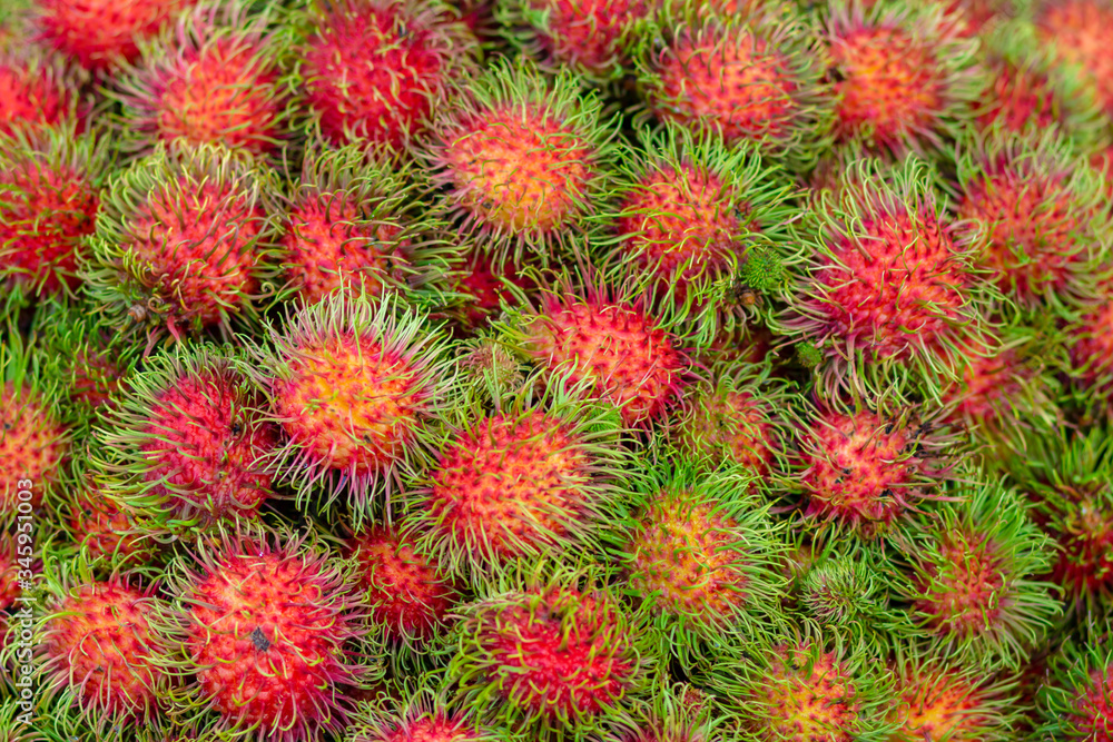 Close up many red rambutan in blue basket. rambutan sweet delicious fruit.background of fresh Thai rambutans. red and green. Close up many red rambutan in blue basket. rambutan sweet delicious fruit.background of fresh Thai rambutans. red and green.