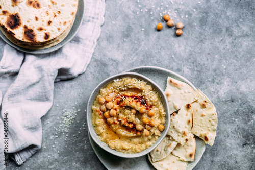 hummus in a plate on a table with corn tortillas