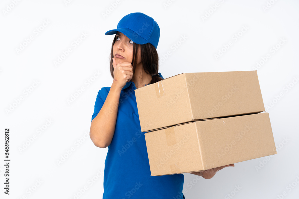 Young delivery brunette girl over isolated white background having doubts and with confuse face expression Young delivery brunette girl over isolated white background having doubts and with confuse face expression