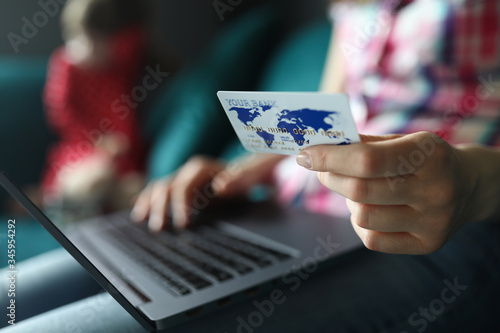 Female hand hold white plastic credit card closeup background. Distance telework concept