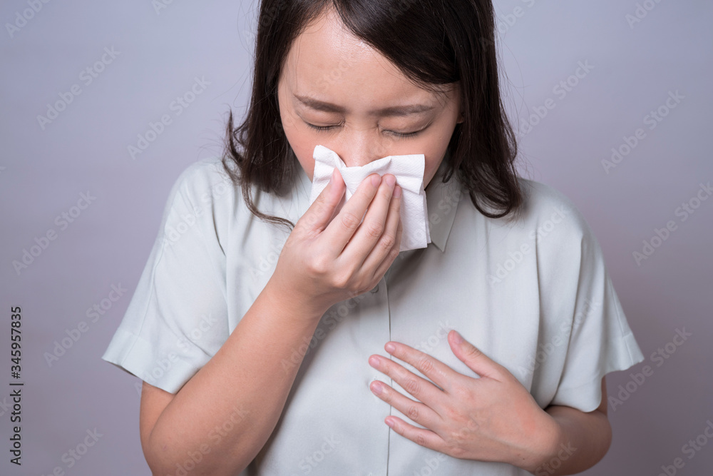 Health care and medical concepts, Sick asian woman, She coughed and sneezed from the flu symptoms, Isolated on gray background. Health care and medical concepts, Sick asian woman, She coughed and sneezed from the flu symptoms, Isolated on gray background.