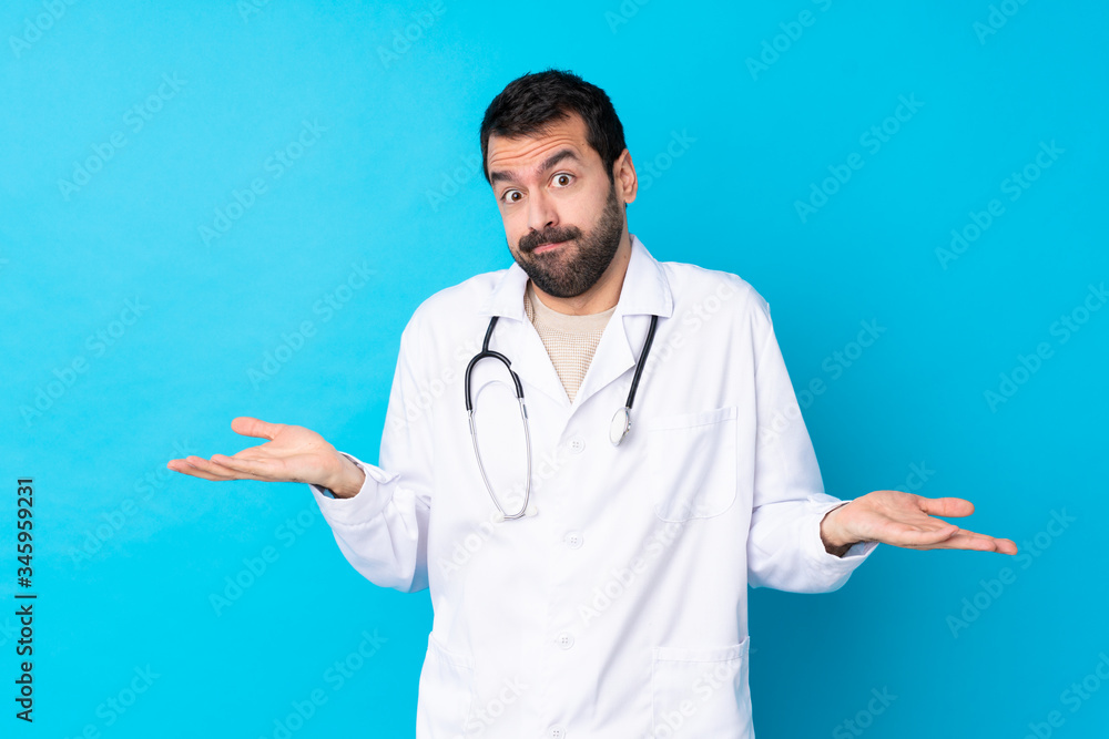 Young caucasian man over isolated background wearing a doctor gown and having doubts Young caucasian man over isolated background wearing a doctor gown and having doubts