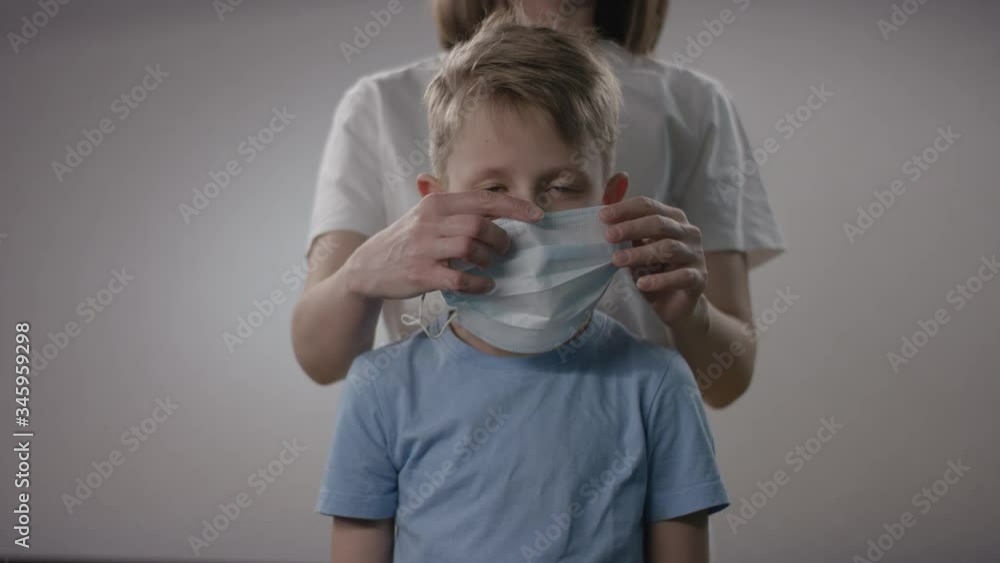 Health protection concept of a caucasian mother protecting her blonde young child with a face protection during the Covid19 pandemic