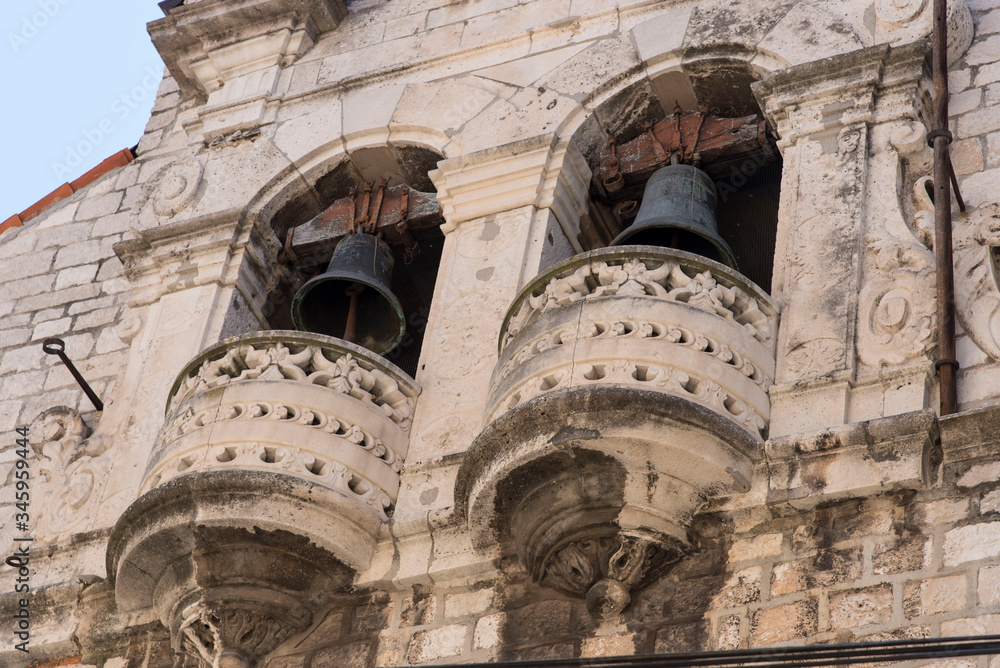 Bell tower with double bell in a church, in Sibenik, city of Croatia, Europe, located next to the mouth of the river Krka on the Adriatic sea coast