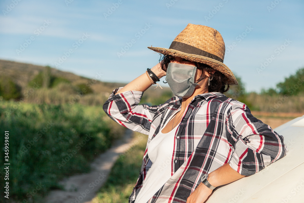 Young farmer woman with straw hat and surgical mask