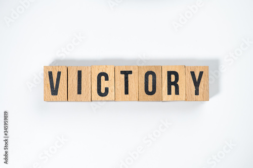 " VICTORY " text made of wooden cube on White background.