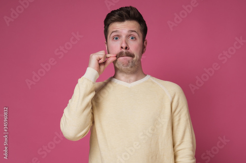 man with mustache, making gesture with hand, zipping lips, promising to keep secret