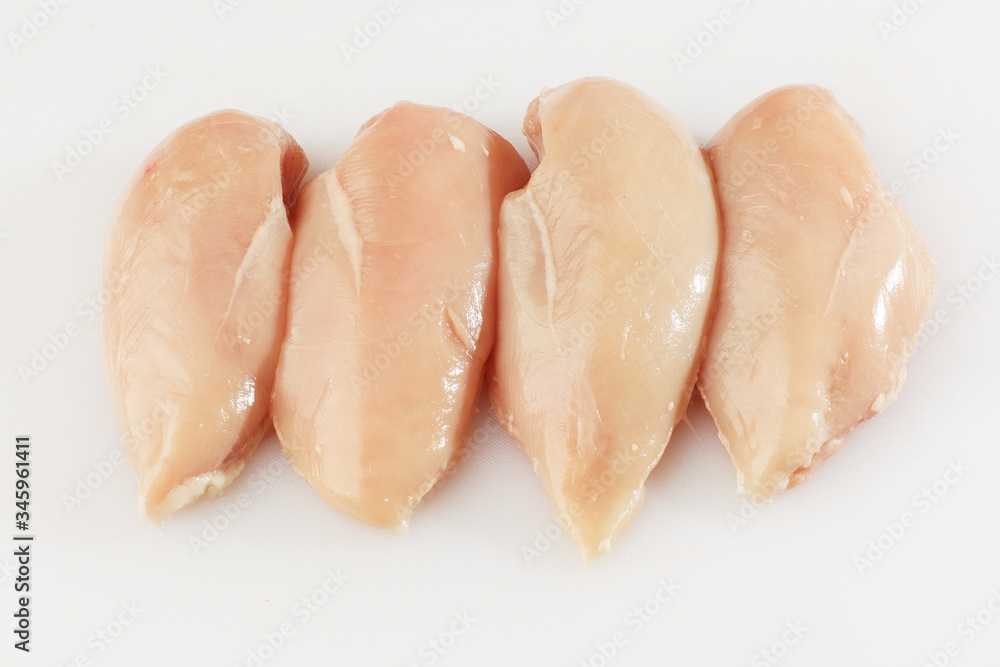 Chicken fillet isolated on a white background. Raw chicken breast fillets. top view with copy space. Flat lay composition with raw breasts. Space for text. Meat shop.