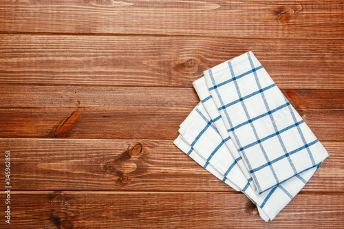 Top view on a dark wooden table with a linen kitchen towel or textile napkin. a tablecloth on a countertop made of old wood.