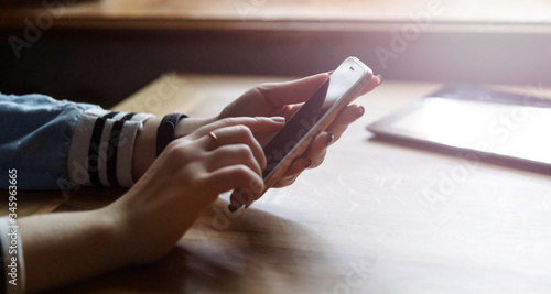 A woman's finger points at a smartphone screen, communicates in social networks, meets a website, searches the Internet, sends an sms, uses a text messenger or online photo