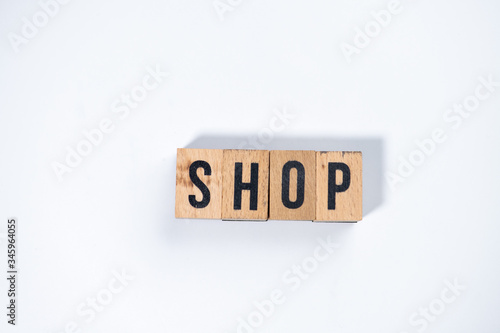 " SHOP " text made of wooden cube on White background.