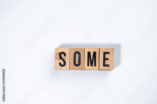 " SOME " text made of wooden cube on White background.