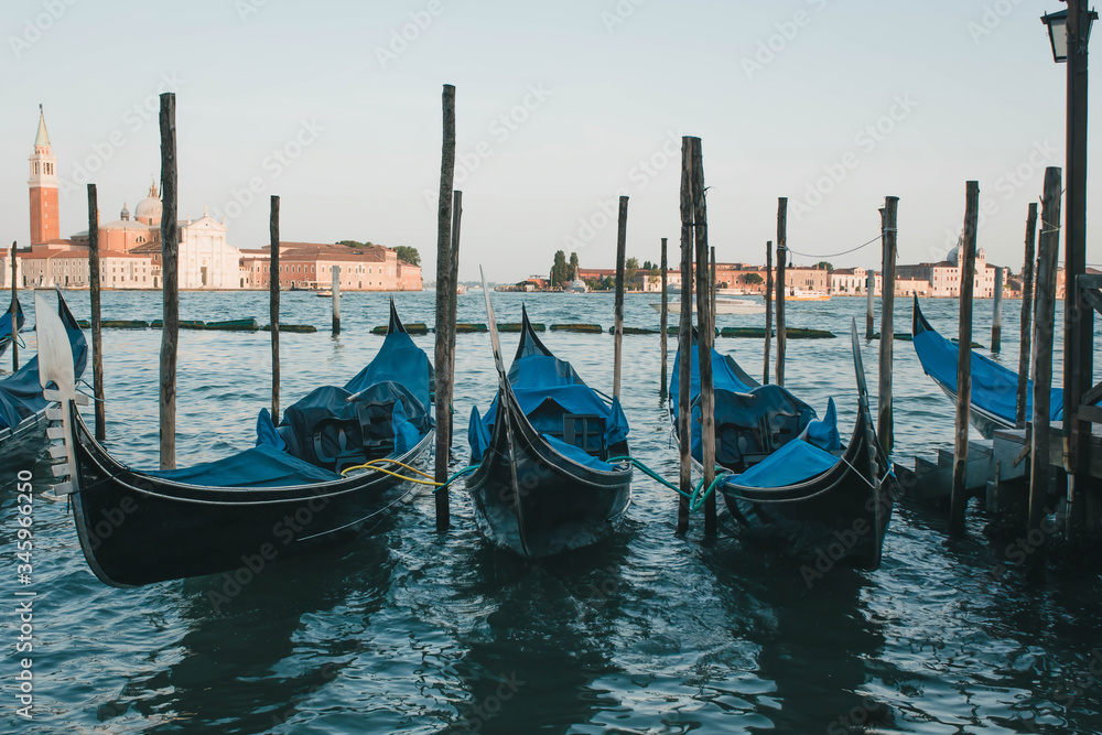 Photograph of a set of gondolas parked on a pier in Venice