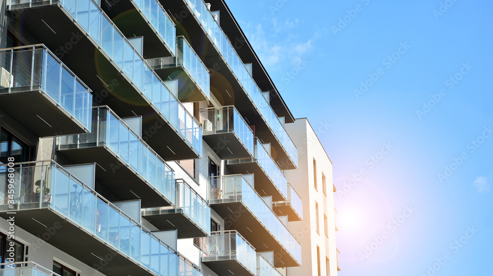 Modern apartment buildings on a sunny day with a blue sky. Facade of a modern apartment building. Glass surface with sunlight. Modern apartment buildings on a sunny day with a blue sky. Facade of a modern apartment building. Glass surface with sunlight.
