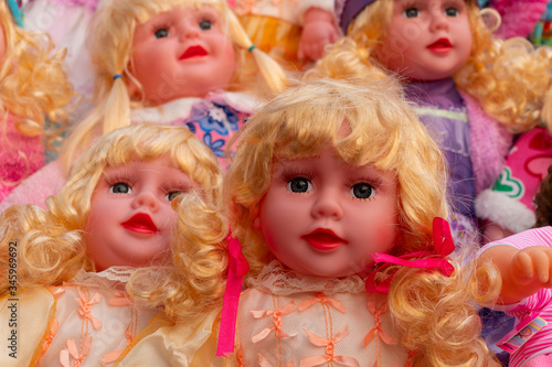 Colourful tiny blonde baby dolls for sale at retail shop at Christmas market, New Market area, Kolkata, West Bengal, India.
