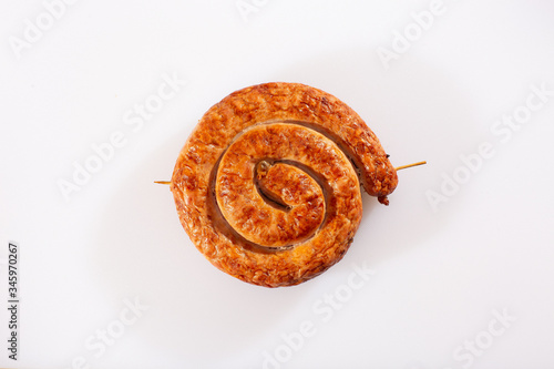 Obraz na płótnie Snail sausage in traditional spiral on white background. Grilled round sausages . Delicious barbecue. There is a delicious fresh traditional village sausage in a natural shell, rolled into a snail. w salonie
