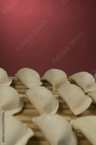 Raw dumplings, pierogi or pyrohy, varenyky, vareniki, served with cottage cheese on board. National Russian cuisine, natural organic homemade bakery product