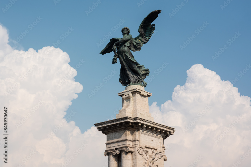Fototapeta premium Escultura de un ángel con el cielo y nubes de fondo en Roma