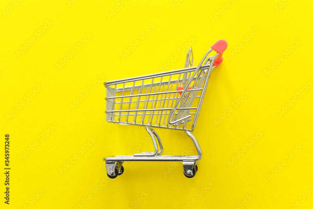 Image of shopping cart over yellow background Image of shopping cart over yellow background