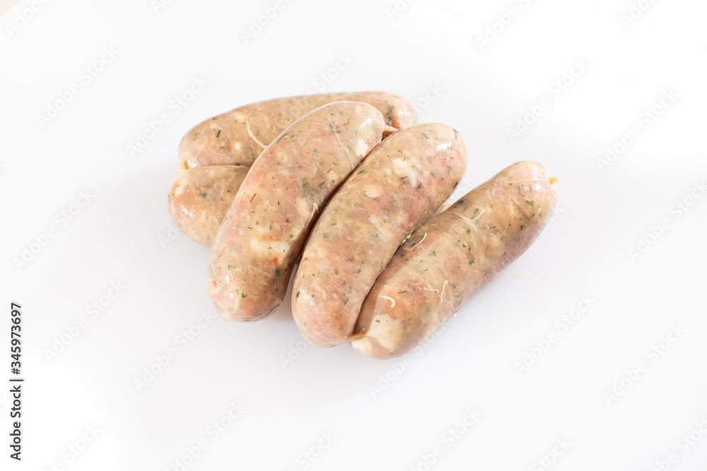 Raw pork beef sausages on white background. Traditional German homemade sausages. Delicious raw meat for barbecue. Advertising for meat shop and farm. Top view. Space for text Raw pork beef sausages on white background. Traditional German homemade sausages. Delicious raw meat for barbecue. Advertising for meat shop and farm. Top view. Space for text