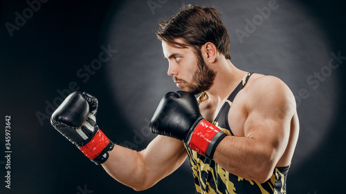 A man in Boxing gloves. A man Boxing on a black background. The concept of a healthy lifestyle © fusssergei