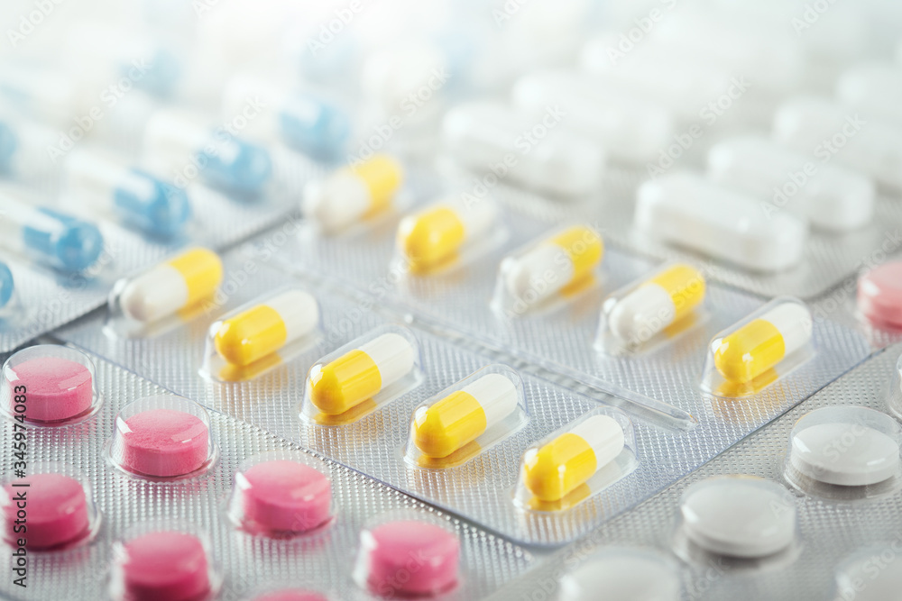 pile of medical pills in red, blue and yellow colors in silver plastic packaging pile of medical pills in red, blue and yellow colors in silver plastic packaging