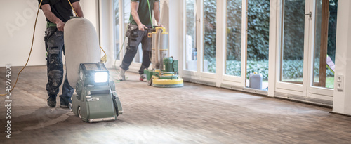 Handwerker schleifen einen Parkettboden