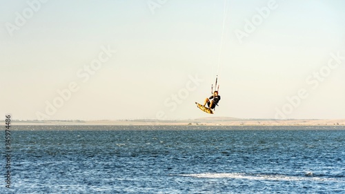Man kitesurfer rides kite jumping. Black Sea coast on sunny day. Blagoveshenskaya. Anapa, Russia.
