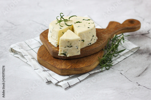Tasty soft cheese with spice of rosemary on wooden board photo