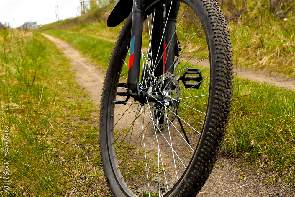 Obraz premium Wheel of a bicycle with disc brakes on a dirt road