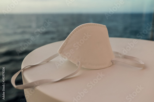 Medical mask on table on a sea background. Concept of prevention  Quarantine  COVID-19.