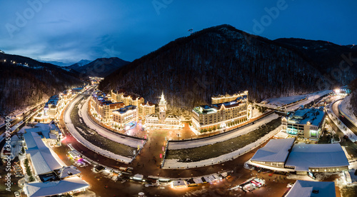 Aerial view of Rosa Khutor Ski Resort in the evening, mountains covered by snow in Krasnaya Polyana, Russia. photo