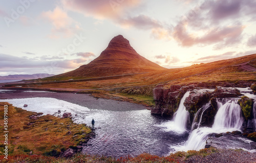 Scenic image of Iceland. Great view on famouse Mount Kirkjufell with Kirkjufell waterfall with colorful sky during sunset. Wonderful Nature landscape. Iconic location for landscape photographers © jenyateua