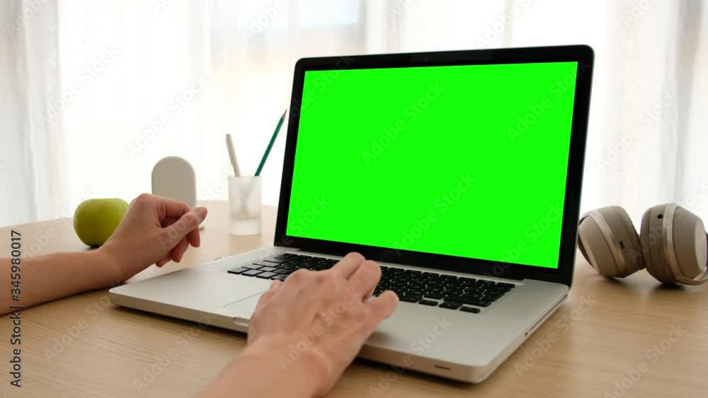 Female hands on touchpad on laptop with green screen. Office person using laptop computer with laptop green screen Female hands on touchpad on laptop with green screen. Office person using laptop computer with laptop green screen