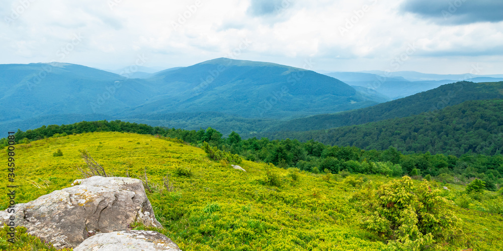 beautiful summer landscape in mountains. green grassy meadow on the hill side. view in to the distant range beneath a blue sky with clouds beautiful summer landscape in mountains. green grassy meadow on the hill side. view in to the distant range beneath a blue sky with clouds