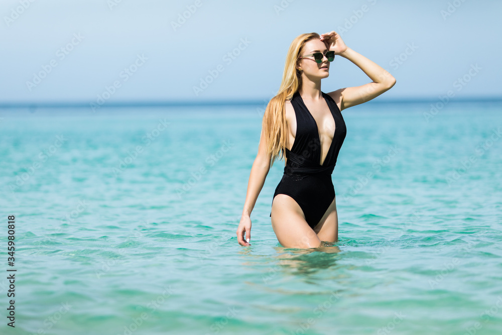Beautiful tanned woman in bikini on the beach. Summer beach vacation