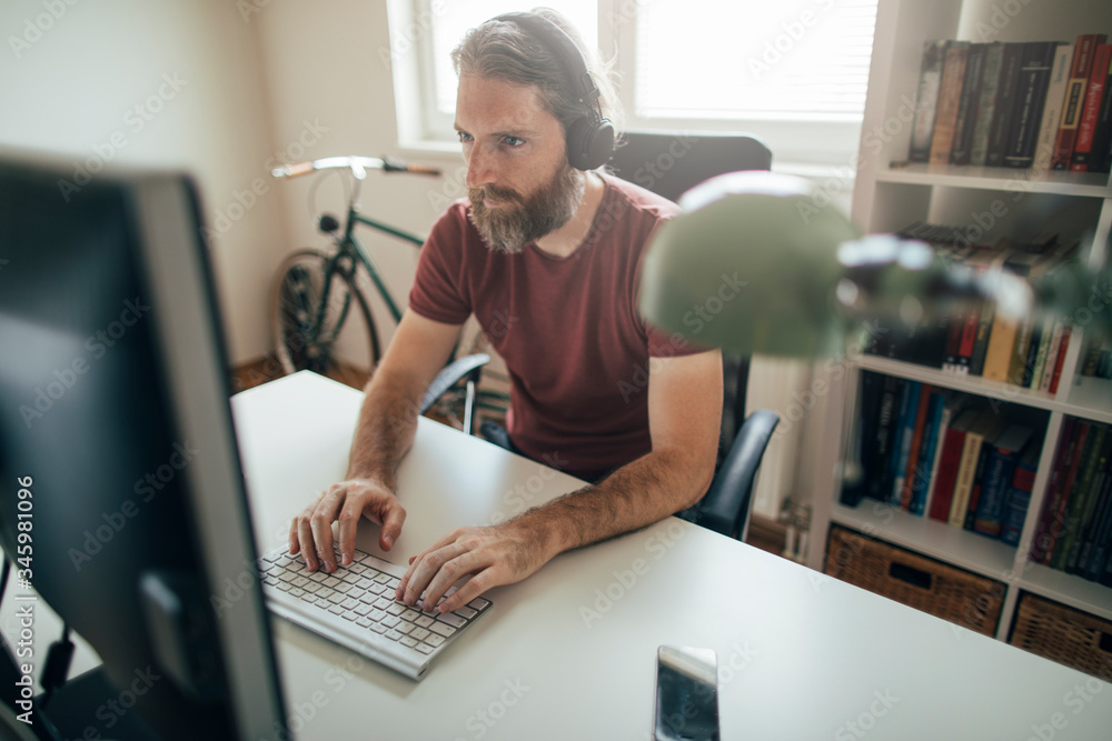 Businessman working on computer from his home office desk Businessman working on computer from his home office desk