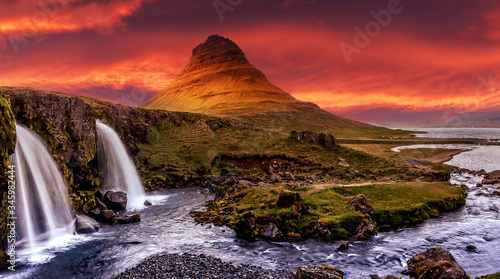 Scenic image of Iceland. Great view on famouse Mount Kirkjufell with Kirkjufell waterfall with colorful sky during sunset. Wonderful Nature landscape. Iconic location for landscape photographers