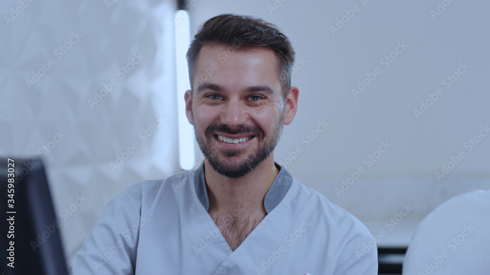 Attractive man cosmetologist consulting a customer in spa salon. Portrait of positive young doctor smiling holding vitamins using computer. Skin care and health concept. Attractive man cosmetologist consulting a customer in spa salon. Portrait of positive young doctor smiling holding vitamins using computer. Skin care and health concept.