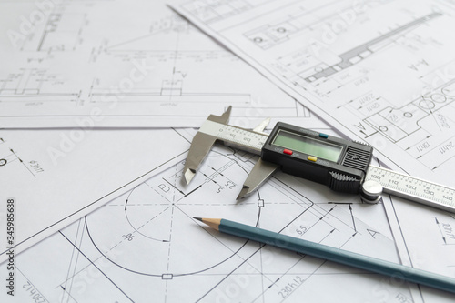 Top view of a caliper measuring tool, pencil and detail drawings.Engineering drawings, metal detail.