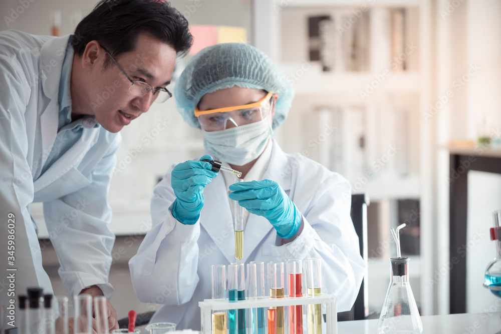 Scientist hold pipette adding fluid to test tubes or glassware with copy space using as background science, medical , education, biology, chemistry concept. Scientist hold pipette adding fluid to test tubes or glassware with copy space using as background science, medical , education, biology, chemistry concept.