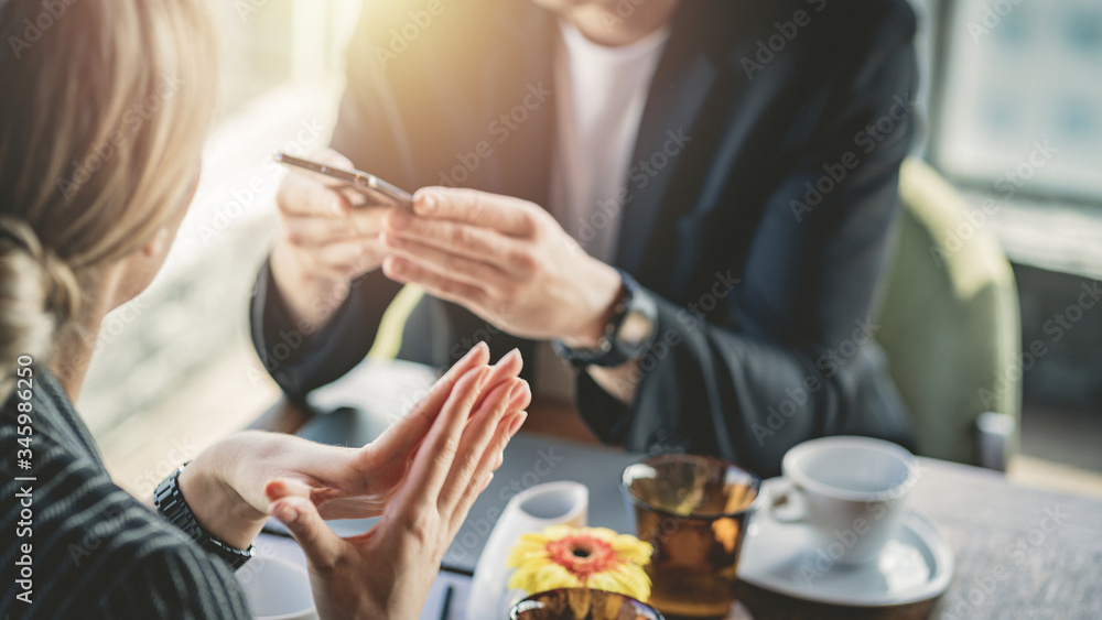 Man looking at smartphone and ignoring his partner in a cafe. Man looking at smartphone and ignoring his partner in a cafe.
