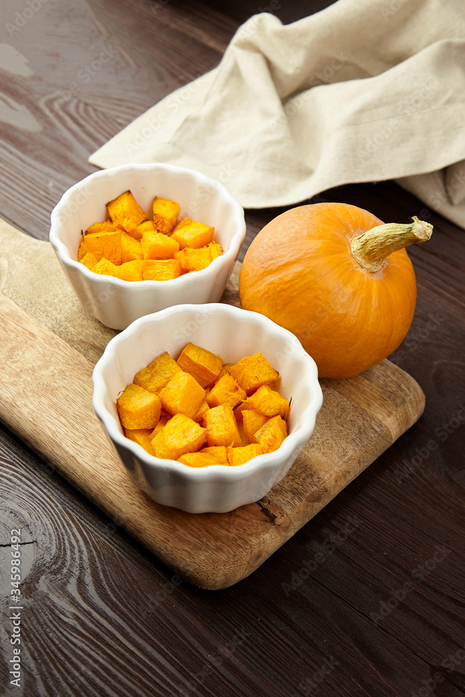 Baked pumpkin in white ceramic bowl on wooden background Baked pumpkin in white ceramic bowl on wooden background