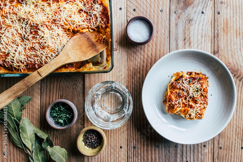 Lasagnes à la bolognaise servies dans une assiette et plat de lasagnes photo