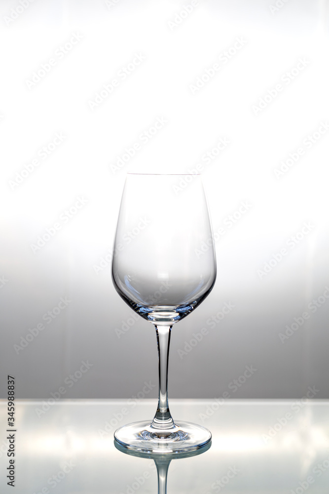 Empty wine glass on glass table with copy space for text or design.