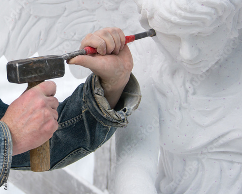 Tela Sculptor at work. Stone carving. Hands with a hammer.