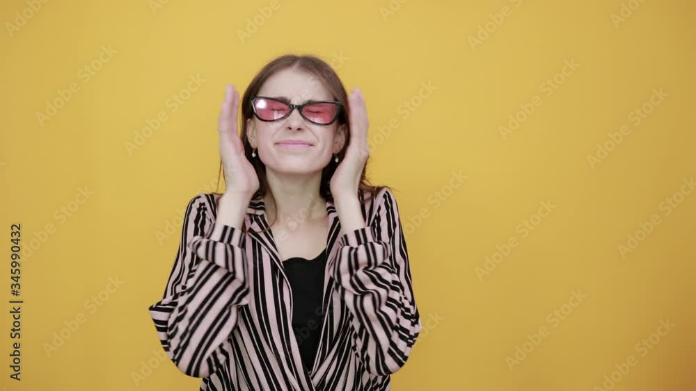 Cute Young Woman Light Brown In Striped Pink, Black Shirt On A Yellow Background, Upset Girl Covered Her Face With Hands Cute Young Woman Light Brown In Striped Pink, Black Shirt On A Yellow Background, Upset Girl Covered Her Face With Hands