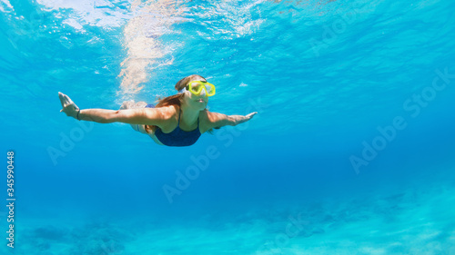 Happy family - active young woman in snorkeling mask dive, swim underwater to see tropical fishes in sea lagoon pool. Travel adventure, swimming activity, watersports on summer beach cruise with kid