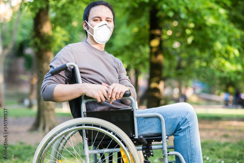 Fototapeta Portrait of a masked man on a wheelchair during coronavirus pandemic